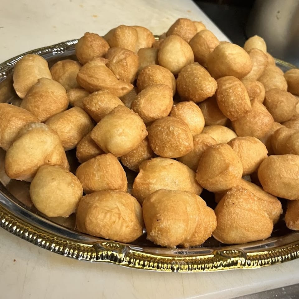 A silver platter piled high with golden-brown, bite-sized fried dough balls from Bear Mountain Pizza & Cafe.